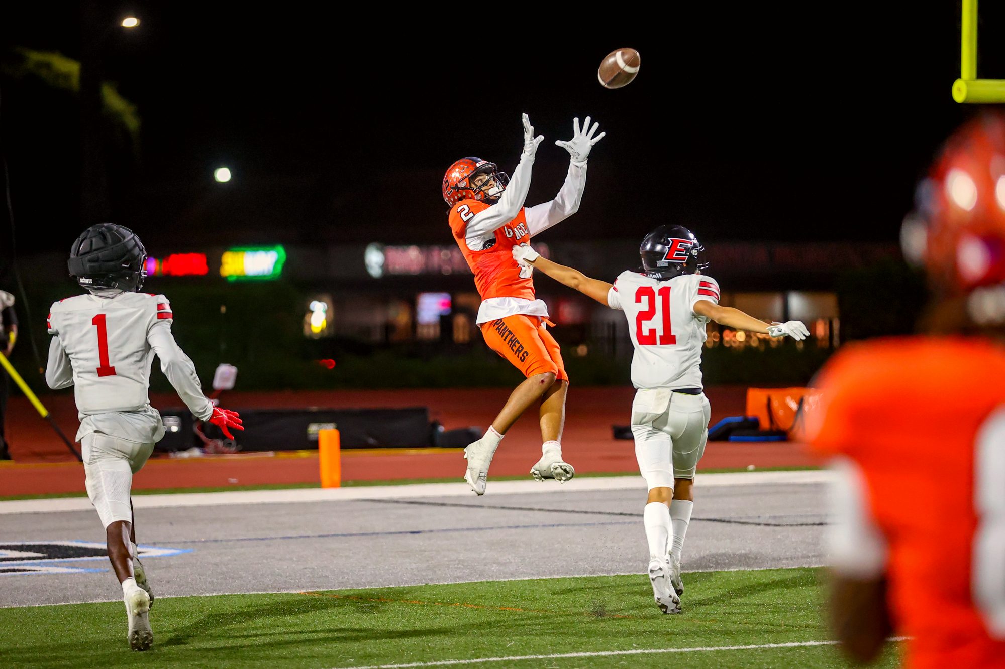 Orange Panthers #21 rising for a catch under the lights