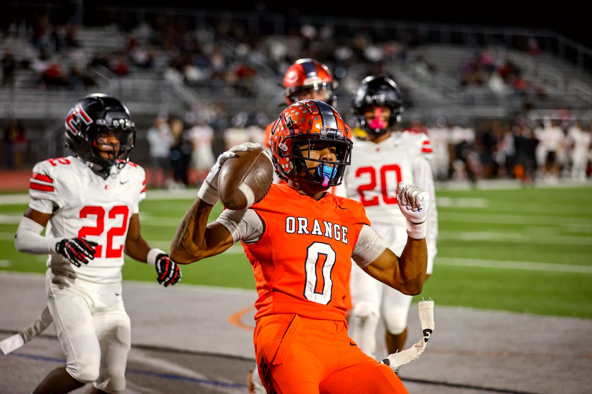 Orange Panthers #0 stiff-arms a defender in the orange home jersey