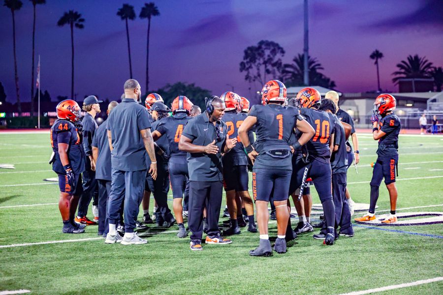 Orange Panthers huddle at sunset